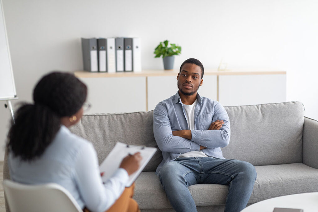 client on couch talks with therapist about trauma and mental health