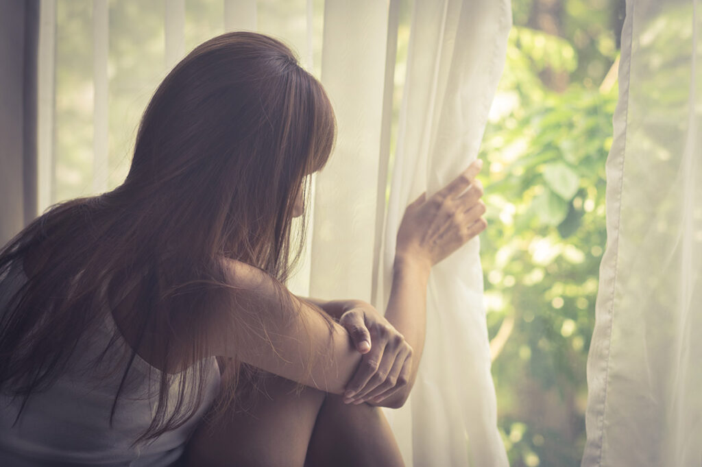 woman looks out of window and wonders what is a social phobia