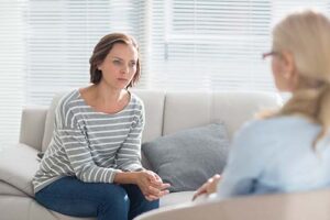 woman in striped shirt talks with therapist about an adhd treatment program 