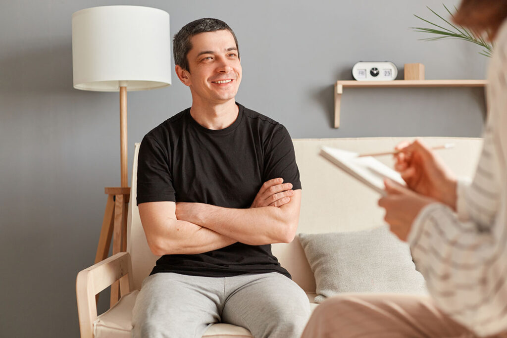 man sitting on couch talks to therapist about how to manage anger