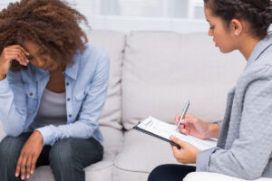 woman on couch talks with therapist about therapy for trauma
