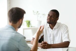 man talks with therapist in motivational interviewing treatment 