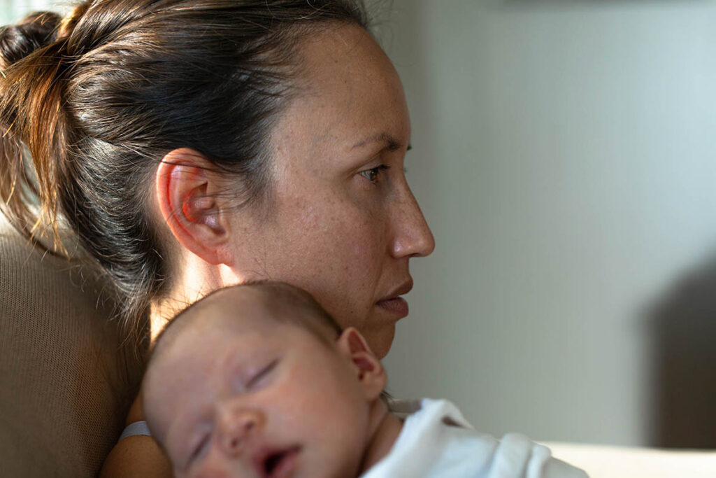 a mother holds her baby and experiences depression after giving birth