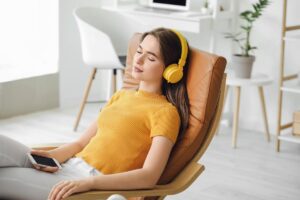 a person sits in a chair with headphones during music therapy for depression